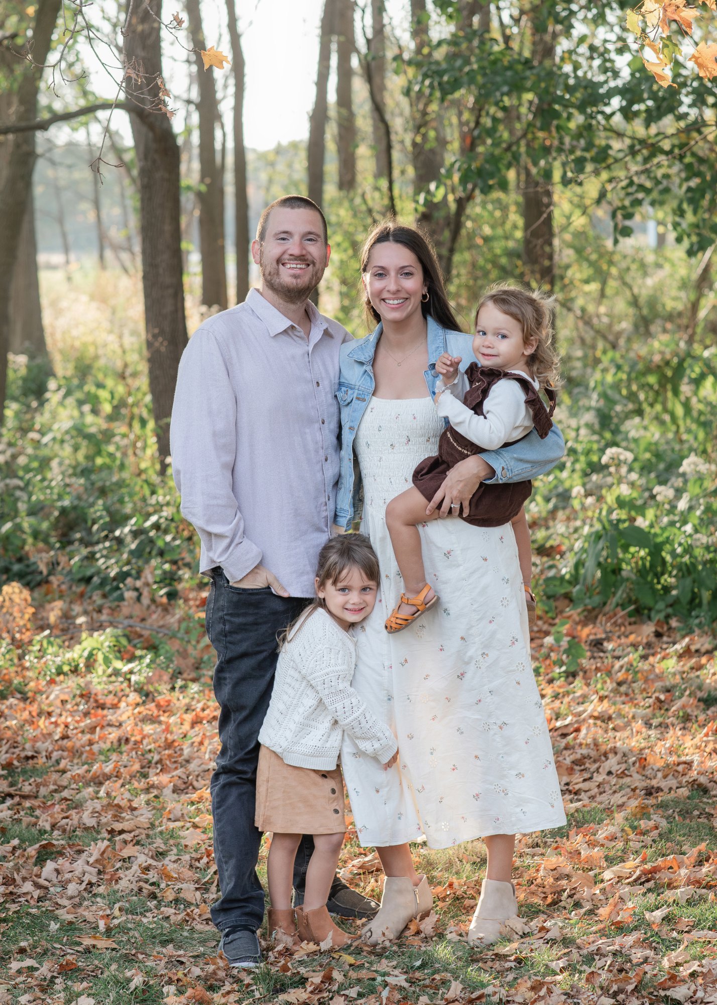 Sean with his wife and their two daughters on a fall afternoon